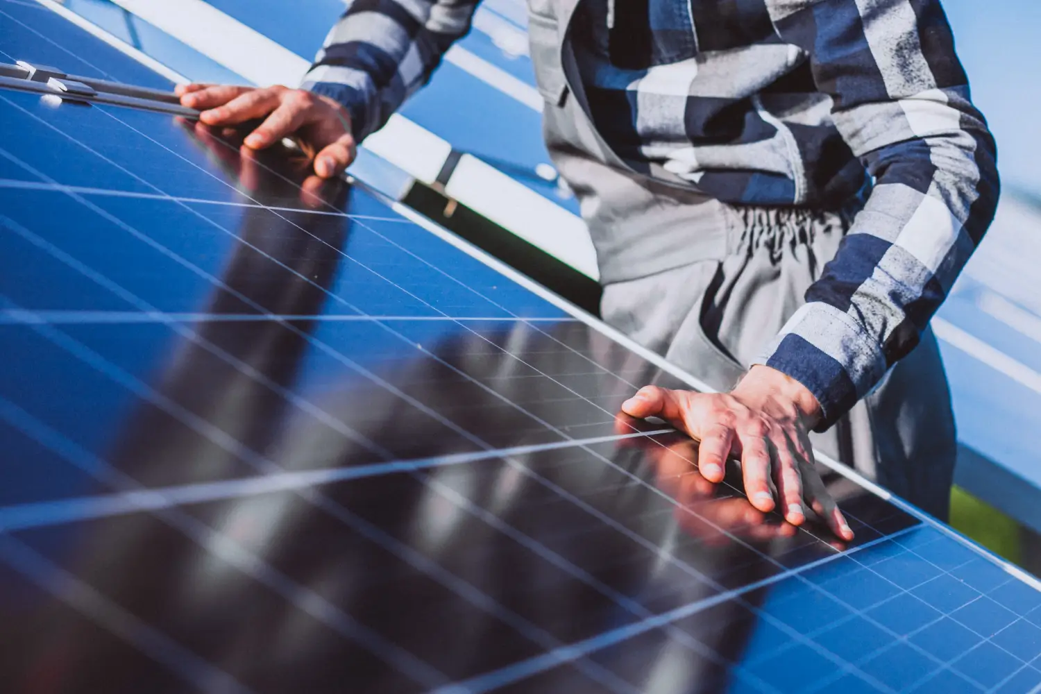Technician gently cleaning solar panels on a Sydney home using purified water and soft equipment